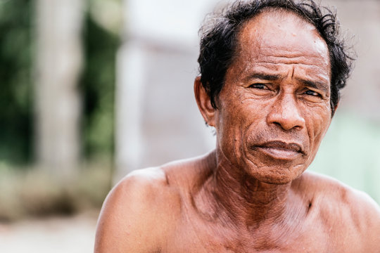 Shirtless Asian man looking at camera