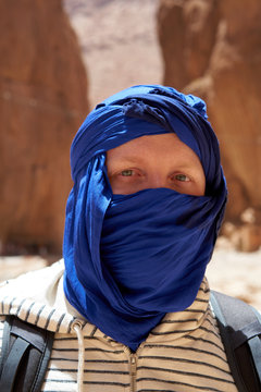 Man with a tied blue berber tagelmust scarf, portrait, Atlas Mountains in Morocco.          