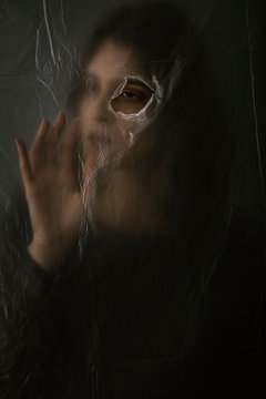 Woman behind blurry plastic