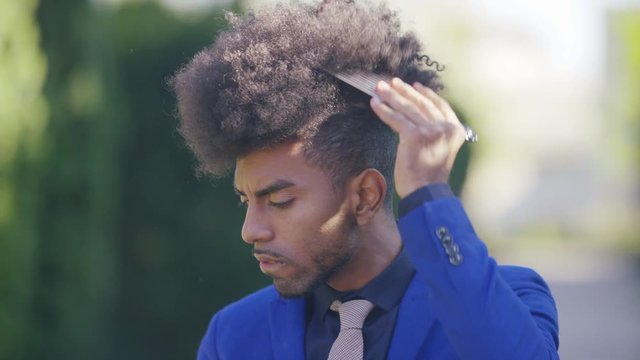 Attractive male in a suit combing his stylish hair