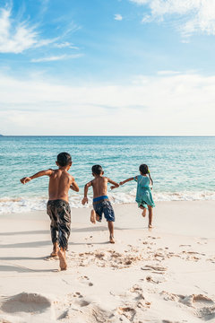 Group of cute Asian kids having fun in the beach