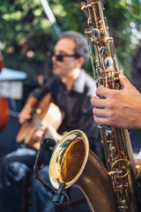 Obraz premium man playing saxophone with a guitarist behind 