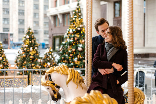Young couple riding roundabout on winter day