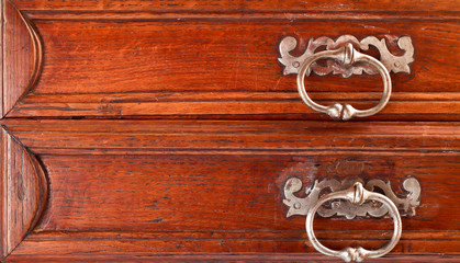 Handles on drawers of an old vintage wooden chest of drawers