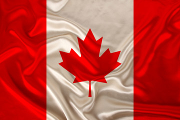 photo of the national flag of Canada on a luxurious texture of satin, silk with waves, folds and highlights, closeup, copy space, illustration