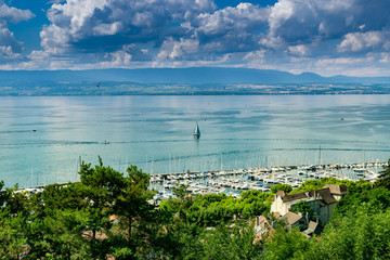 View from the viewpoint of the port of Thonon les Bains, boats, Lake Geneva, and the blue sky with clouds.Haute-Savoie in France.