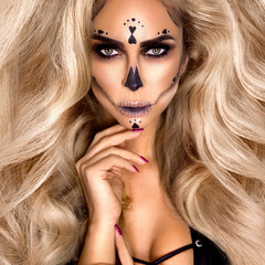 Halloween Sexy Witch portrait. Beautiful young woman in witches makeup with long curly colorful...