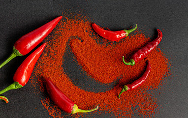 Fiery red pepper on a black background. View from above.