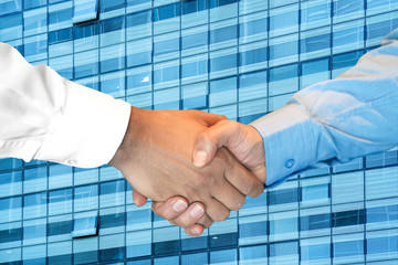 Businessmans partnership handshaking process. Skyscraper on the background