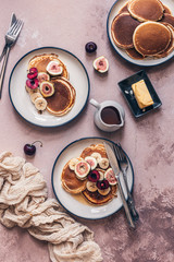 Freshly baked pancakes with fruits, butter and maple syrup