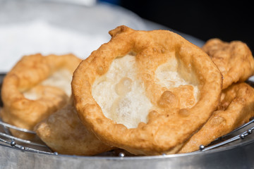Freshly fried donuts in direct sunlight at a food market, ready to eat food with selective focus