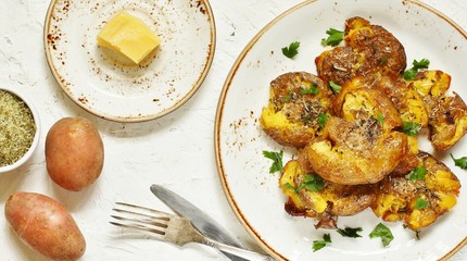 crushed potatoes. smashed potatoes. recipes for Australian cuisine. the potatoes are boiled in a shell, broken and baked in an oven with spices. top view