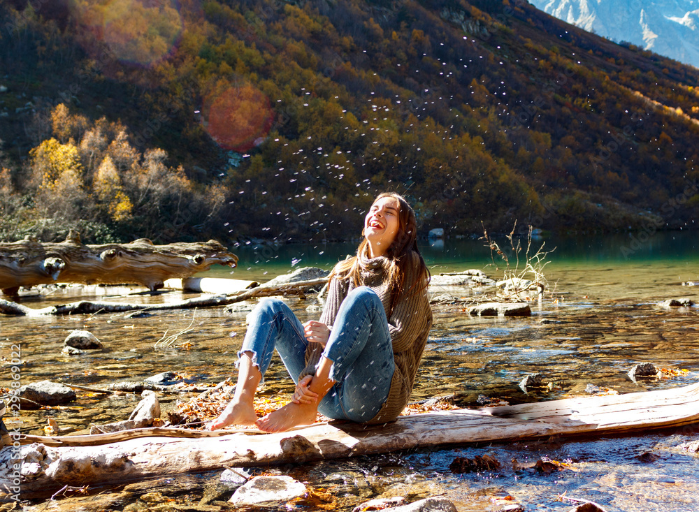 Wall mural nice girl traveler on a mountain lake