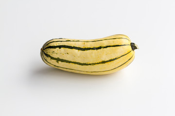 Fresh delicata squash centered and isolated on a white background.