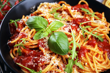 Plate of delicious spaghetti Bolognaise or Bolognese with savory minced beef and tomato sauce garnished with parmesan