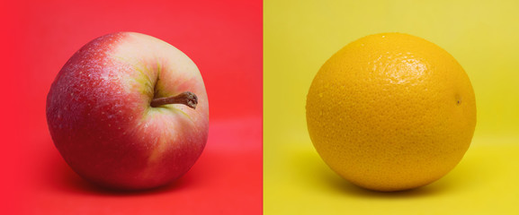 Apple and orange on a isolated red and yellow mixed background
