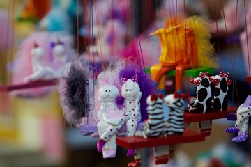 cat puppets hanging on a swing for sale at art festival in Tel Aviv, Israel