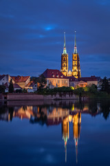 Fototapeta na wymiar Cathedral of St. John the Baptist reflecting in Oder river, Wroclaw, Poland