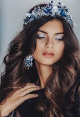 Portrait of beautiful brunette woman in crown with makeup in fashion black clothes