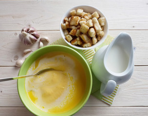 Pumpkin soup with croutons on a wooden table.