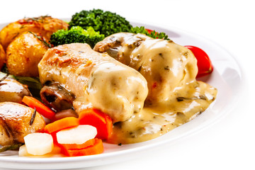 Wrapped pork chop with baked potatoes and vegetables