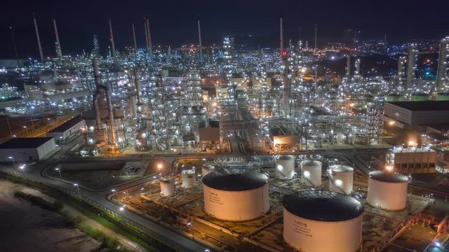 Aerial drone hyper lapse over oil refinery factory at night. Oil industrial, technology or business concept. Shot by 4K high resolution drone.