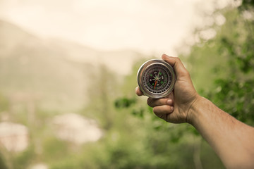 man hand compass in nature