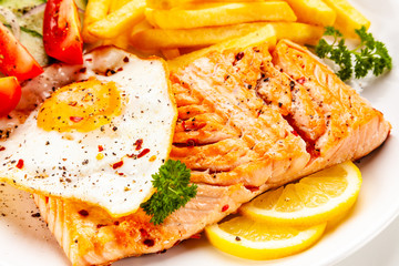 Fried salmon, French fries and vegetables