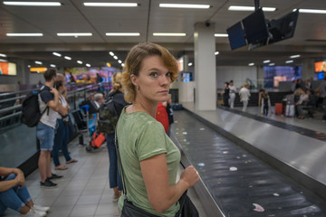 passengers are waiting for luggage at the passport in the airport lobby.