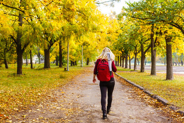 girl with a backpack in the autumn park