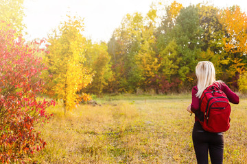 girl with a backpack in the autumn park