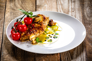 Grilled chicken fillet and vegetables on white plate