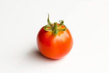 Single fresh tomato centered and isolated on a white background.