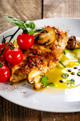 Grilled chicken fillet and vegetables on white plate