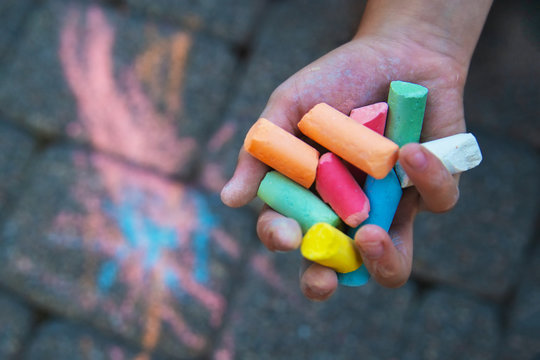 hand child drawing chalk colours on blackboard