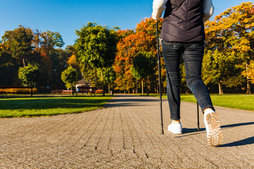 Nordic walking - middle-age woman working out in city park