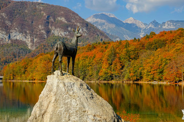 COPY SPACE: Bronze statue of a mountain goat looks away from lake Bohinj in fall