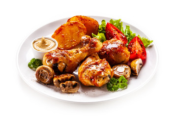 Grilled chicken drumsticks with baked potatoes and vegetables