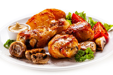 Grilled chicken drumsticks with baked potatoes and vegetables