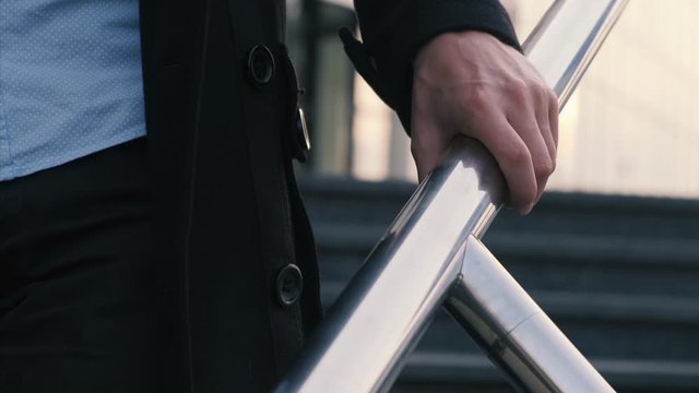 A man touches the railing with his hand, slow motion. Virus and epidemic concept