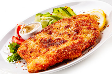 Fried pork chop and vegetable salad on white background