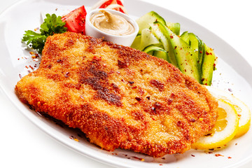 Fried pork chop and vegetable salad on white background