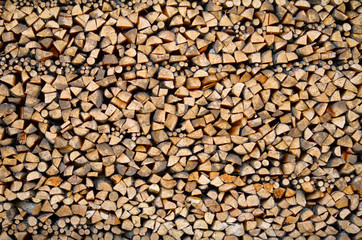 Wall of harvested firewood for the stove. Background. Texture.
