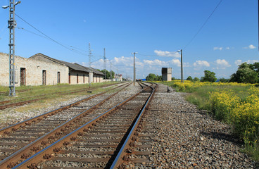 Fototapeta na wymiar Industrial landscape. Railroad - rails, rubble. High voltage transmission lines.