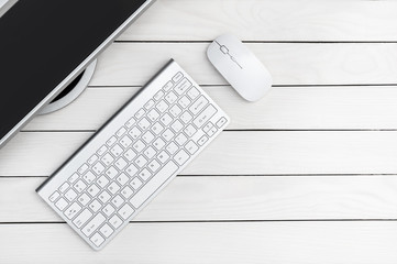 Computer mouse, keyboard and monitor on the desk near wall. Top view. Space for text.
