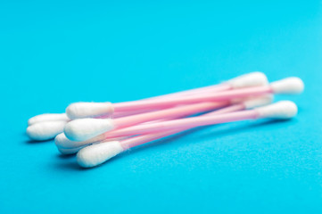 Heap of ear sticks on blue background.