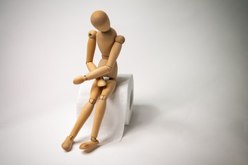 figure of a man sitting on a roll of toilet paper holding his stomach, diarrhea, abdominal pain, food poisoning, intestinal infection