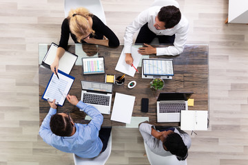 Young Businesspeople Discussing Data In Meeting Room