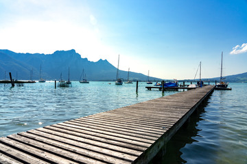 Mondsee Lake in Austria with pier, boats and mountains at summer