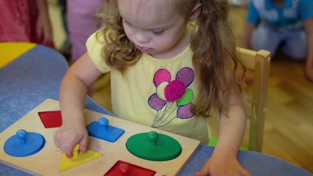 Girl with down syndrom developing motor skills in rehab center for special children